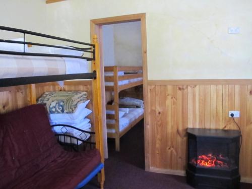 a room with two bunk beds and a fireplace at Cedar Lodge Cabins in Mount Victoria