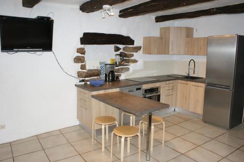 uma cozinha com um frigorífico, uma mesa e bancos em Gîte Laboule pour 4 personnes em Laboule