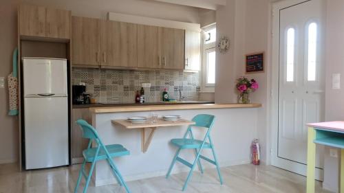 a kitchen with blue chairs and a white refrigerator at Eleni Apartment in Sami