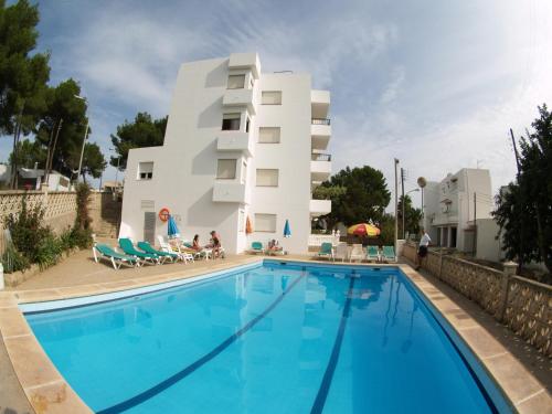 un hotel con piscina frente a un edificio en Apartamentos Mar Bella en Es Cana