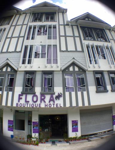 a large white building with a hotel at Hotel Flora Plus in Cameron Highlands