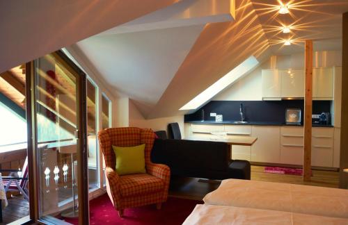ヴァイセンゼーにあるDer Ronacherfelsのベッド1台、椅子、キッチンが備わる客室です。
