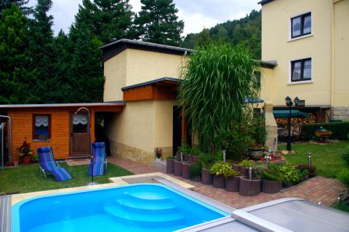 a swimming pool in the yard of a house at Ferienhaus und Ferienwohnung Büttner in Rathmannsdorf