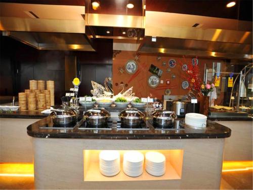 a counter in a kitchen with pots and pans at China National Convention Center Grand Hotel in Beijing
