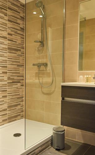 une douche avec une porte vitrée dans une salle de bain dans l'établissement L'Annexe, à Saint-Malo