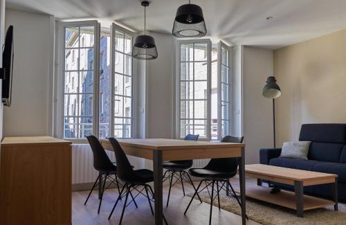 un salon avec une table, des chaises et un canapé dans l'établissement L'Annexe, à Saint-Malo