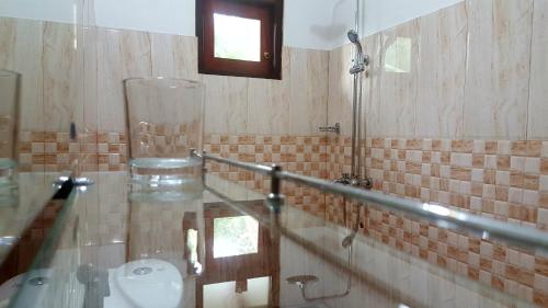 a bathroom with a glass counter top and a sink at Villa Happy Home in Bentota