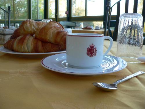 a table with a cup of coffee and a plate of bread at Chateau de la Rozelle in Cellettes