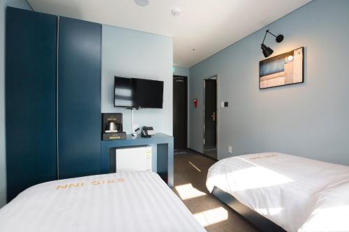 a bedroom with a white bed and a blue wall at Grid Inn Hotel in Seoul