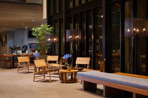 a lobby with chairs and tables and a restaurant at BATIQA Hotel Jababeka Cikarang in Cikarang