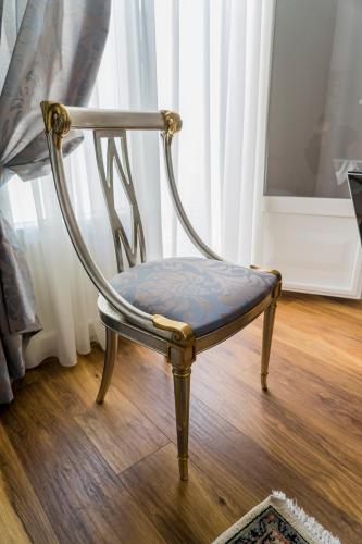 a chair with a blue seat sitting on a wooden floor at Le Bijou Luxury Rooms & Suites in Veria