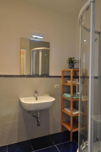 a bathroom with a sink and a glass shower at La Ginestra Amalfi Dreams in Minori