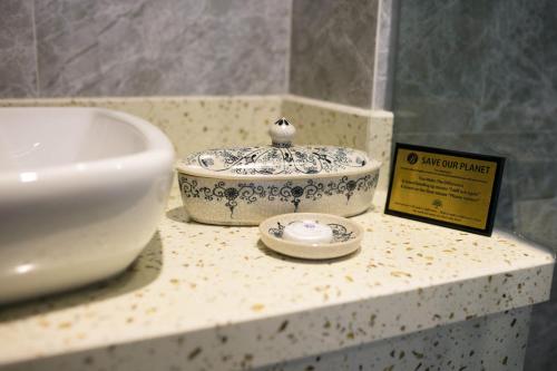 a bathroom counter with a sink and a bowl at Bonsella Hotel in Hanoi