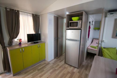 Cette petite chambre comprend un réfrigérateur et un four micro-ondes. dans l'établissement Mobile Home, à Duna Verde