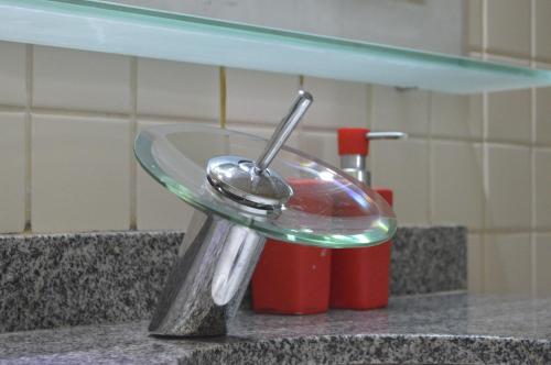 a bathroom sink with a spoon on a counter at Yatch Village Flat in Natal