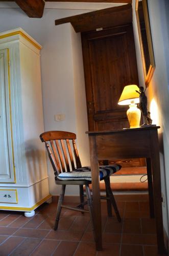 a wooden desk with a lamp and a chair at Casale I Burroni in Arezzo