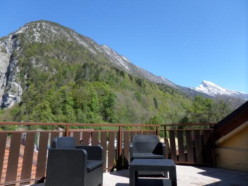 a group of chairs sitting on a balcony with a mountain at Hôtel Du Midi in Thônes
