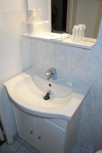 a white sink in a bathroom with a mirror at D'win in Paris