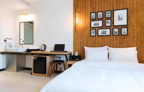a bedroom with a bed and a sink and a mirror at Boutique Hotel XYM Pyeongtaek in Pyeongtaek