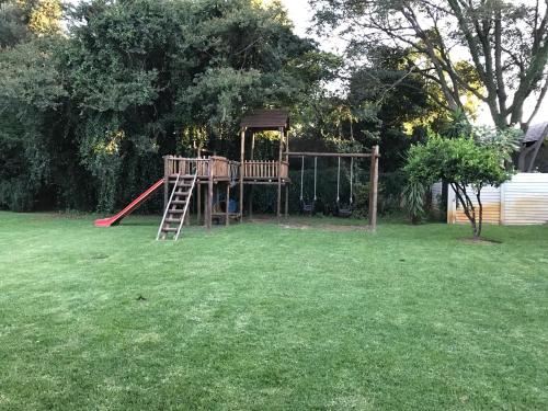 a playground with a ladder in a yard at Aerotropolis Guest Lodge in Kempton Park
