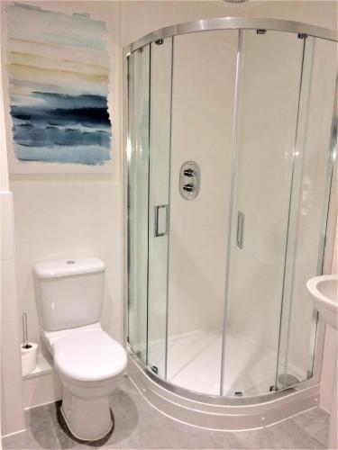 a bathroom with a shower with a toilet and a sink at Westlake Apartments in Peterborough