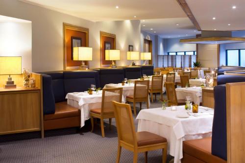 a dining room with tables and chairs and lights at Starhotels President in Genova