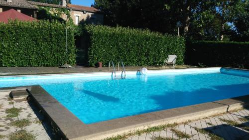 a swimming pool with blue water in a yard at Agriturismo Podernuovo in Acquapendente