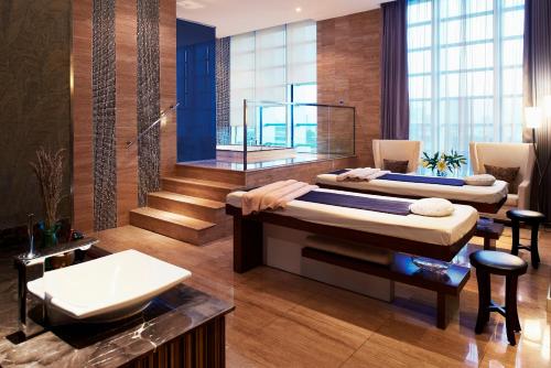 a large room with two beds and a sink at Grand Mercure Danang in Da Nang