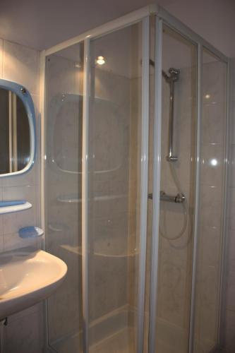 a shower with a glass door in a bathroom at Pensjonat Lazur in Mielno