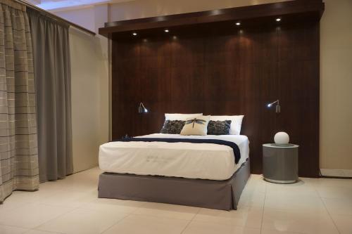 a bedroom with a large bed with a wooden headboard at Hotel 2001 in Maputo