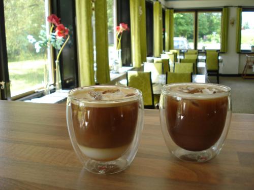 two cups of coffee sitting on a wooden table at Mikkelborg Kro in Rødding