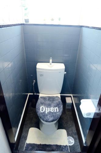 a bathroom with a toilet with an open sign on it at South Island in Itoman