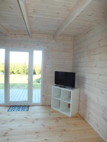 リンにあるDomki Letniskowe Polaの木製の壁に薄型テレビが備わる客室です。