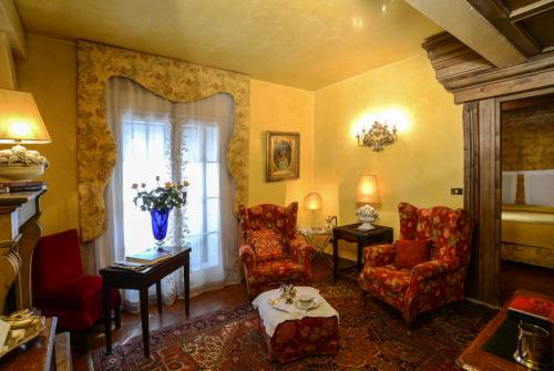 a living room with two chairs and a window at Hotel Gabbia D'Oro in Verona