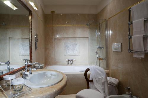 a bathroom with a tub and a sink and a toilet at Hotel Gabbia D'Oro in Verona