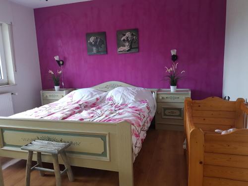 SurwoldにあるFerienwohnung 2 Bauernhof von Edenの紫の壁のベッドルーム1室、ベッド1台、ナイトスタンド2台が備わります。