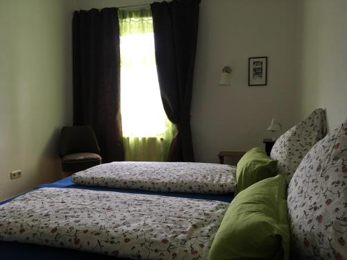 2 Betten in einem Schlafzimmer mit Fenster in der Unterkunft Zur schönen Müllerin in Wredenhagen