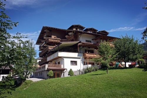 un edificio en la cima de una colina cubierta de hierba en Hotel Eckartauerhof, en Mayrhofen