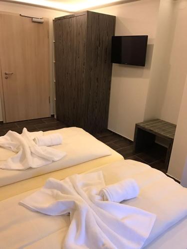 two beds in a room with white towels on them at Hotel Sophia in Warendorf