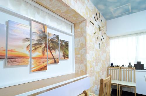 a dining room with palm trees paintings on the wall at South Island in Itoman