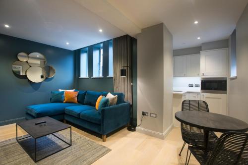a living room with a blue couch and a table at No.8 Waterloo Street in Birmingham
