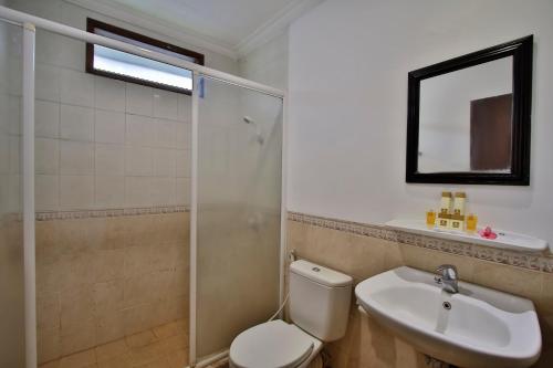 a bathroom with a toilet and a sink and a shower at The Jayakarta Anyer in Anyer