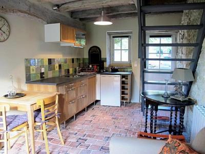 uma cozinha com mesa e cadeiras e um balcão em Le four à pain em Varennes
