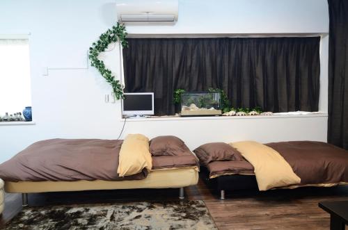 two beds sitting in a room with a window at South Island in Itoman