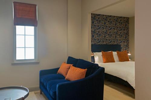 a bedroom with a blue couch and a bed at No.8 Waterloo Street in Birmingham
