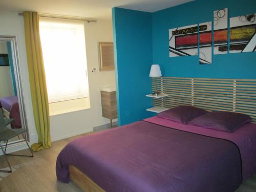 - une chambre avec un lit violet et un mur bleu dans l'établissement Residence du Parc, à Belfort
