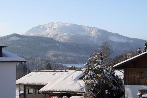 a snow covered mountain in front of a house at Das Ruebezahl in Reit im Winkl