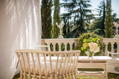 a porch with two chairs and a table with flowers at Country Lodge B&B in Siena