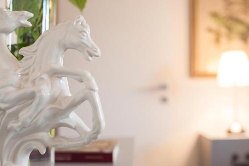 a white statue of a white horse on a table at Country Lodge B&B in Siena