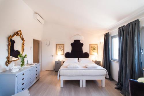 a white bedroom with a large bed and a dresser at Country Lodge B&B in Siena